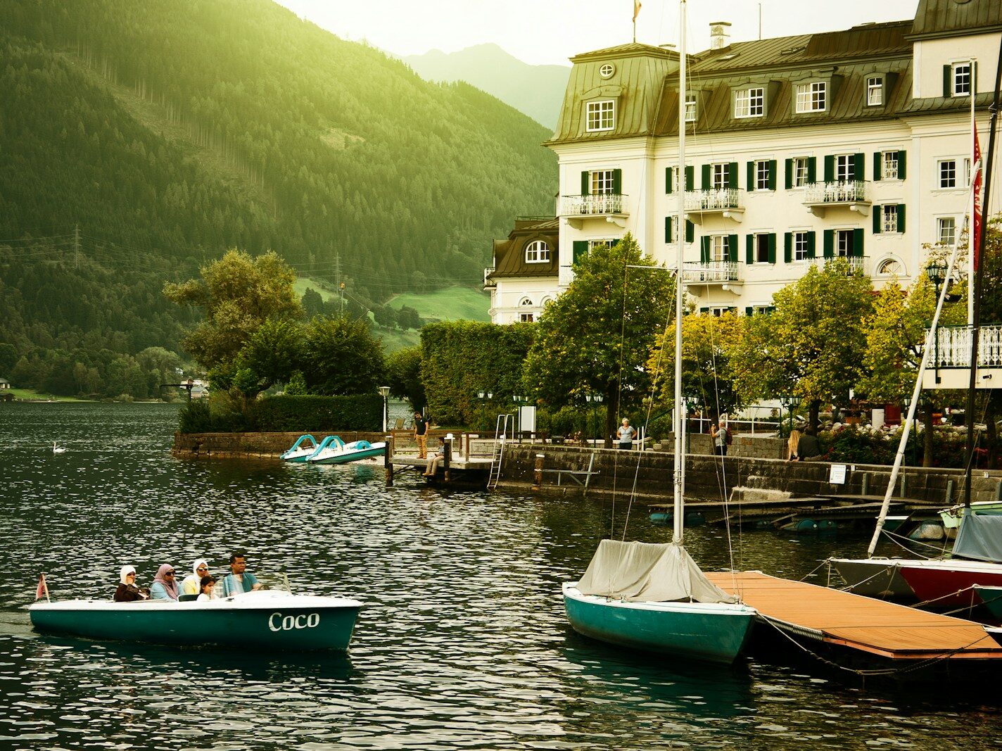 group of people riding on boat near trees and building during daytime