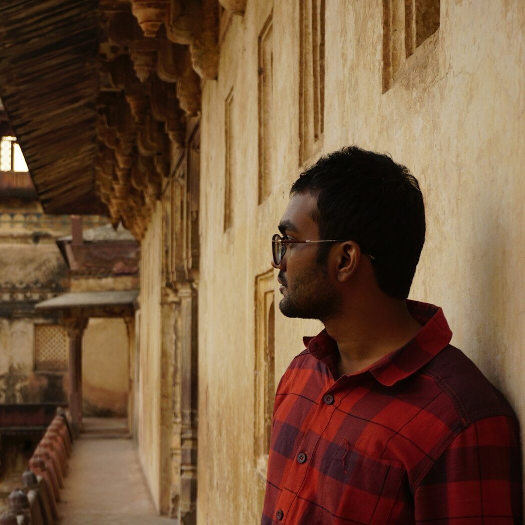 a man leaning against a wall in front of a building