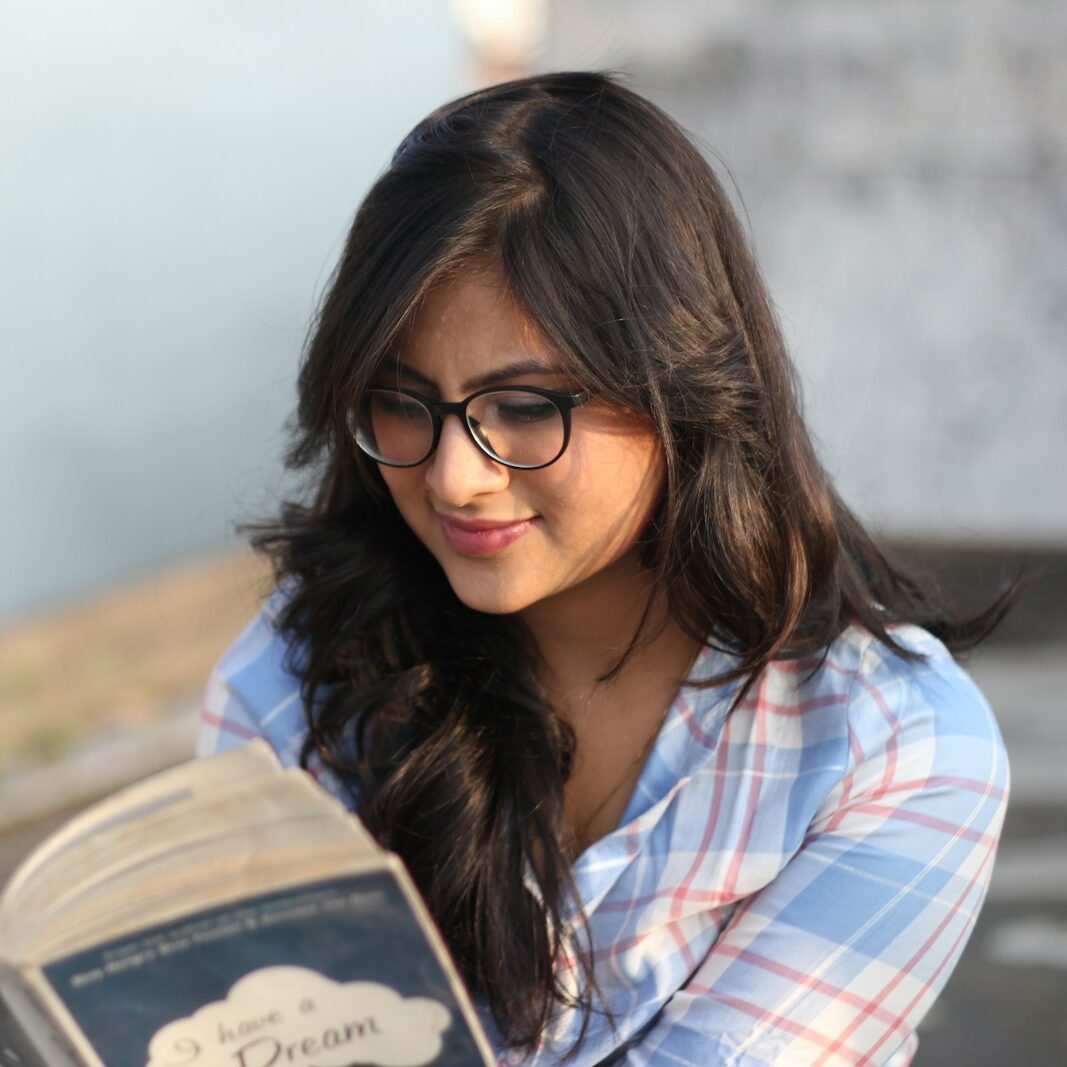 woman in red and white plaid shirt wearing black framed eyeglasses