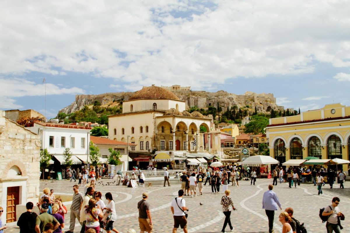 Bustling Monastiraki Square in Athens, Greece, with the iconic Acropolis in the background.