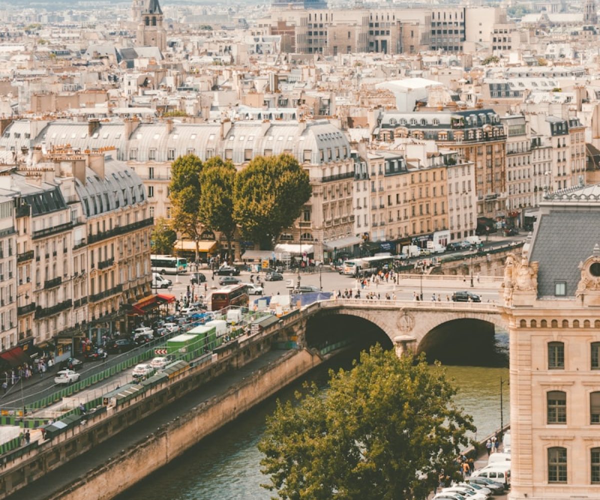 group of people walking near body of water and building under blue sky at daytime